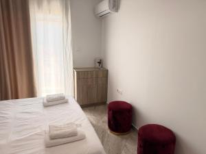 a bedroom with a bed and two red chairs at Central Park Chíos in Chios