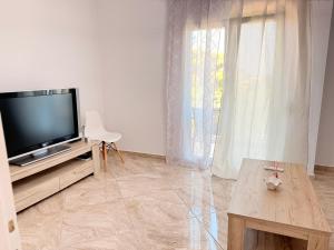 a living room with a television and a table at Central Park Chíos in Chios