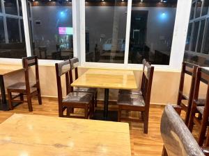 a table and chairs in a restaurant with a window at Seabreeze Village Resort and Restaurant in Gokarn