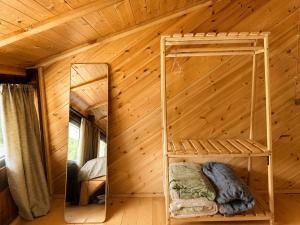 a bedroom in a log cabin with a mirror at Chalet Hatsvali - Ushba Viewpoint Rooms & Café in Mestia