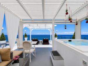 a house on the beach with a hot tub at Panorama Suites & Spa - Adults Only in Stomio