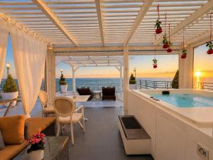 a living room with a jacuzzi tub on a patio at Panorama Suites & Spa - Adults Only in Stomio