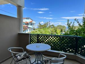 a patio with a table and chairs on a balcony at Aegean Sun Hotel in Skala Rachoniou