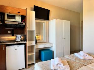a small room with two beds and a microwave at Aegean Sun Hotel in Skala Rachoniou