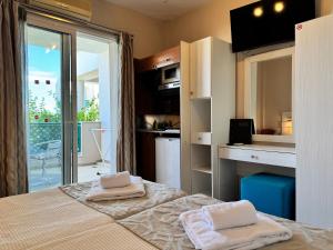 a bedroom with a bed with two towels on it at Aegean Sun Hotel in Skala Rachoniou +50 photos