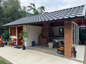 a house with a patio with a roof at Casuta -Dor de Munte -Ceahlau in Bistricioara