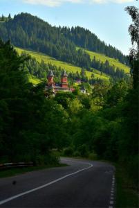 an empty road with a building on the side of a hill at Casuta -Dor de Munte -Ceahlau in Bistricioara