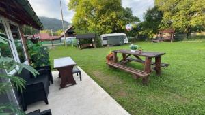 a picnic table and a bench in a yard at Casuta -Dor de Munte -Ceahlau in Bistricioara +6 photos