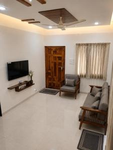 a living room with a couch and a tv at Wale's Hilltop Villa in Kolhapur