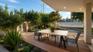 a wooden deck with a table and chairs on it at Garden Bliss Alexandroupolis in Alexandroupoli