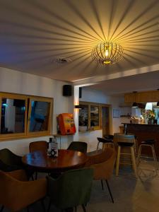 a dining room with tables and chairs and a chandelier at Le Refuge Hotel Restaurant in Ayer