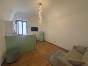 a living room with a couch and a kitchen at La Dimora del Duomo in LʼAquila