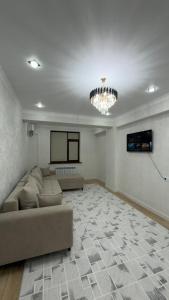 a large living room with a couch and a chandelier at АК Кеме in Osh