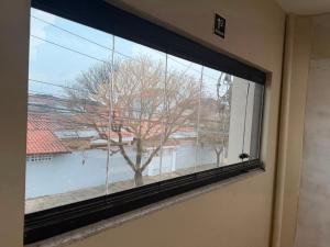 a window with a view of a tree at Pousada SMART AIRPORT 10 min GRU in Guarulhos +11 photos