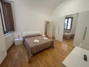 a bedroom with a bed with two towels on it at La Dimora del Duomo in LʼAquila