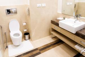 a bathroom with a toilet and a sink at Hotel Nirmla Residency in Brahmapur