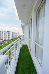 a balcony with green grass and white railing at Golden Pent House in Lucknow