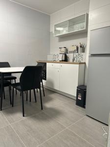 a kitchen with a table and chairs and a refrigerator at Modernes Studio mit Küche, WLAN, Parkplatz in Dingolfing