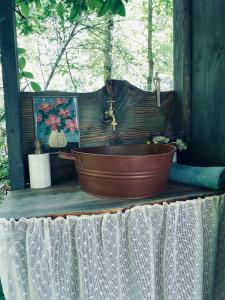 a bath tub on a table with a sink at Zariņmājas Mistērija in Ceļarāji
