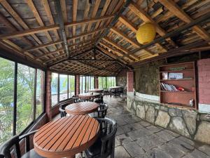 a dining room with tables and chairs and windows at Rock Garden Resort in Pokhara