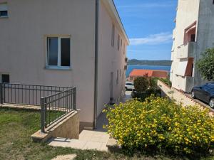 a balcony of a building with yellow flowers next to it at Apartments Čirjak in Sveti Petar