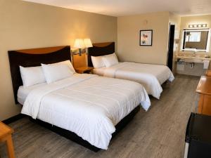a hotel room with two beds and a bathroom at Four Winds Motel & RV Park in Carrizozo