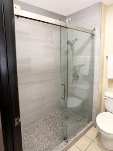 a glass shower stall in a bathroom with a toilet at Four Winds Motel & RV Park in Carrizozo +3 photos