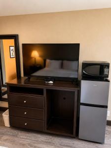 a bedroom with a bed and a desk with a microwave at Four Winds Motel & RV Park in Carrizozo