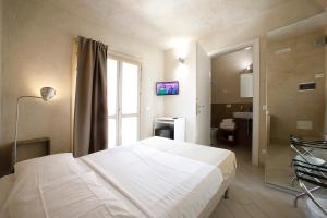 a bedroom with a large white bed and a window at Secret B&B in Trapani