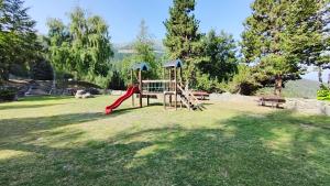 a park with a playground with a slide and a bench at Petit Flocon in Pila