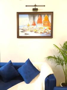 a picture hanging on a wall with a blue couch at Hotel Kashi Remark Suites By G K Group in Varanasi
