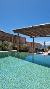 a large swimming pool with a wooden pergola at Endogeios Luxury Villas in Loutraki