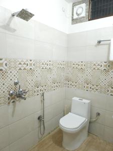a bathroom with a toilet and a shower at Hotel Kashi Remark Suites By G K Group in Varanasi