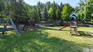 a playground with a slide in the grass at Petit Flocon in Pila