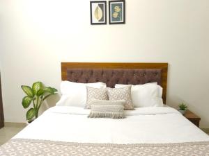 a bed with white sheets and pillows in a bedroom at Hotel Kashi Remark Suites By G K Group in Varanasi