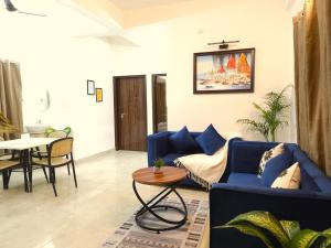 a living room with a blue couch and a table at Hotel Kashi Remark Suites By G K Group in Varanasi