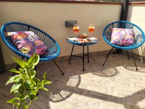 two chairs and a table with two glasses of wine at Appartamento La Terrazza - Località Cala Gavetta in La Maddalena