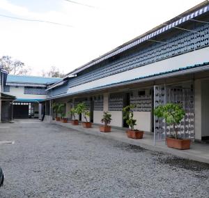 a building with a row of potted plants on the side at Self Contained Studio in Nakuru