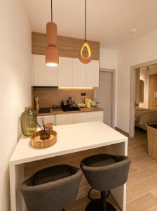 a kitchen with a white counter and two chairs at Noema City View in Xanthi