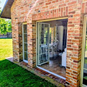 a brick house with sliding glass doors on a patio at Ferienhaus Sükow in Perleberg