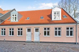 a large pink house with an orange roof at Hotel Varde Garten in Varde