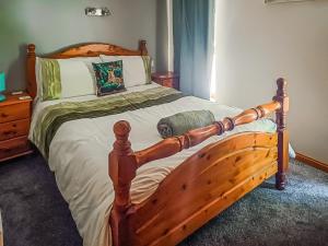 a bedroom with a wooden bed with a wooden frame at Park Lodge in Strachan +3 photos
