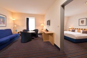 une chambre d'hôtel avec un lit et un canapé dans l'établissement ACHAT Hotel Dresden Elbufer, à Dresde