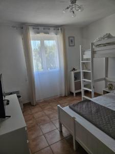 a bedroom with a bunk bed and a window at Maison à 700m de la mer in Bormes-les-Mimosas