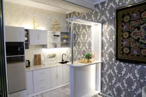 a kitchen with white cabinets and a flower arrangement on a counter at OSMAN villa in Samarkand