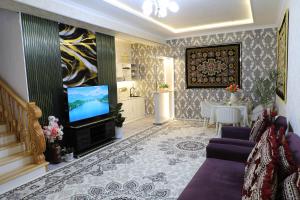 a living room with a television and a table at OSMAN villa in Samarkand