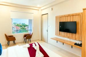 a hotel room with a television and a bed at Hotel 33 Inn in Kānpur