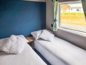 two beds in a room with a window at Peachy in Heysham +18 photos