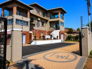 a building with a sign on the driveway at FlowithLin Guesthouse in Durban