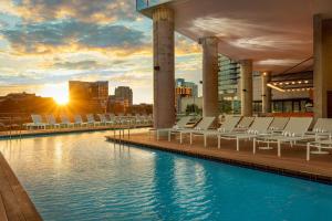 a pool on the rooftop of a building with lounge chairs at W Nashville in Nashville